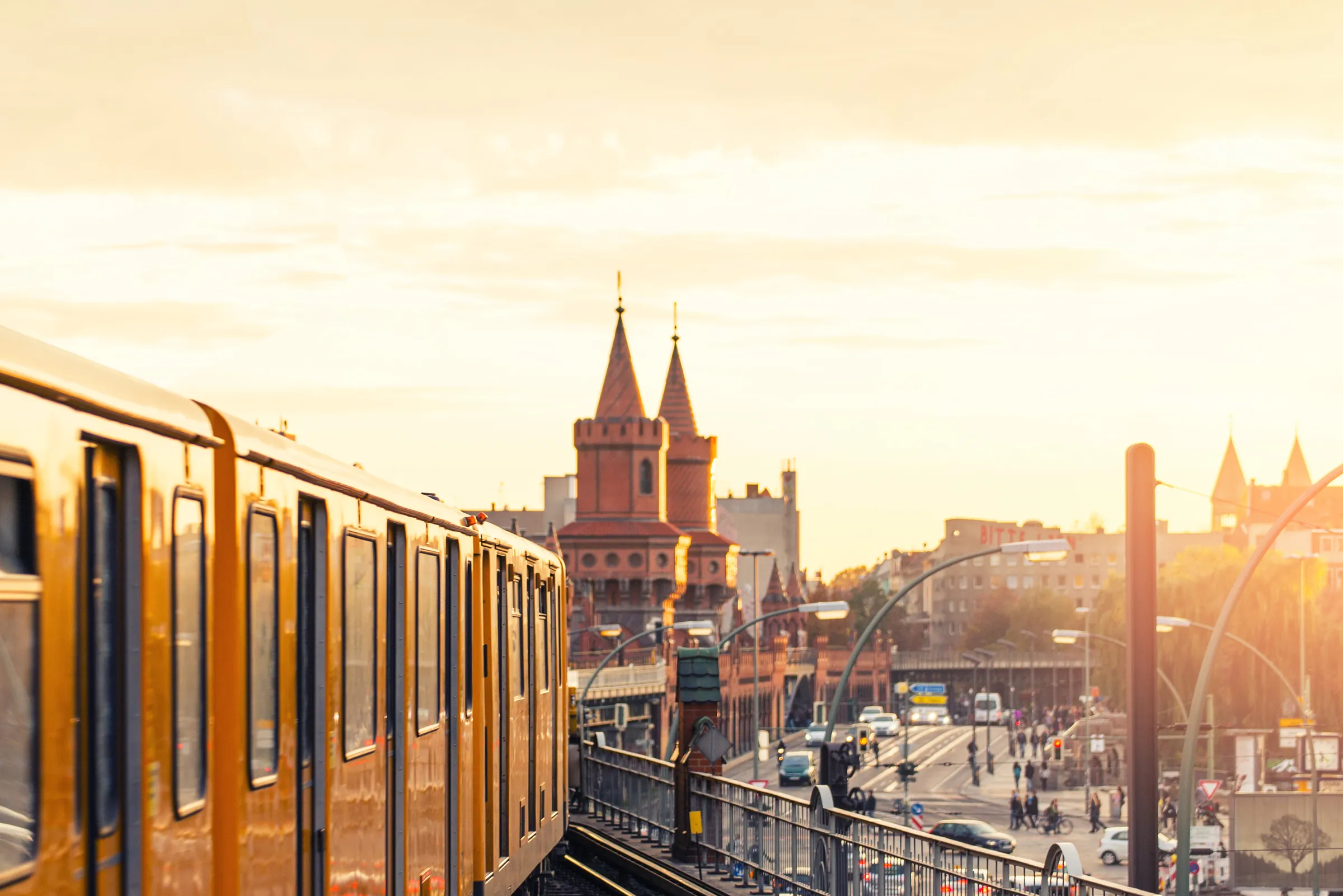 Gelbe U-Bahn auf der Hochbahnstrecke vor der Oberbaumbrücke in Berlin bei Abendsonne