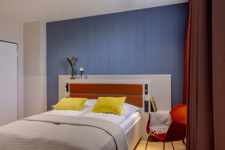 Schlafzimmer mit Doppelbett und gelben Kissen