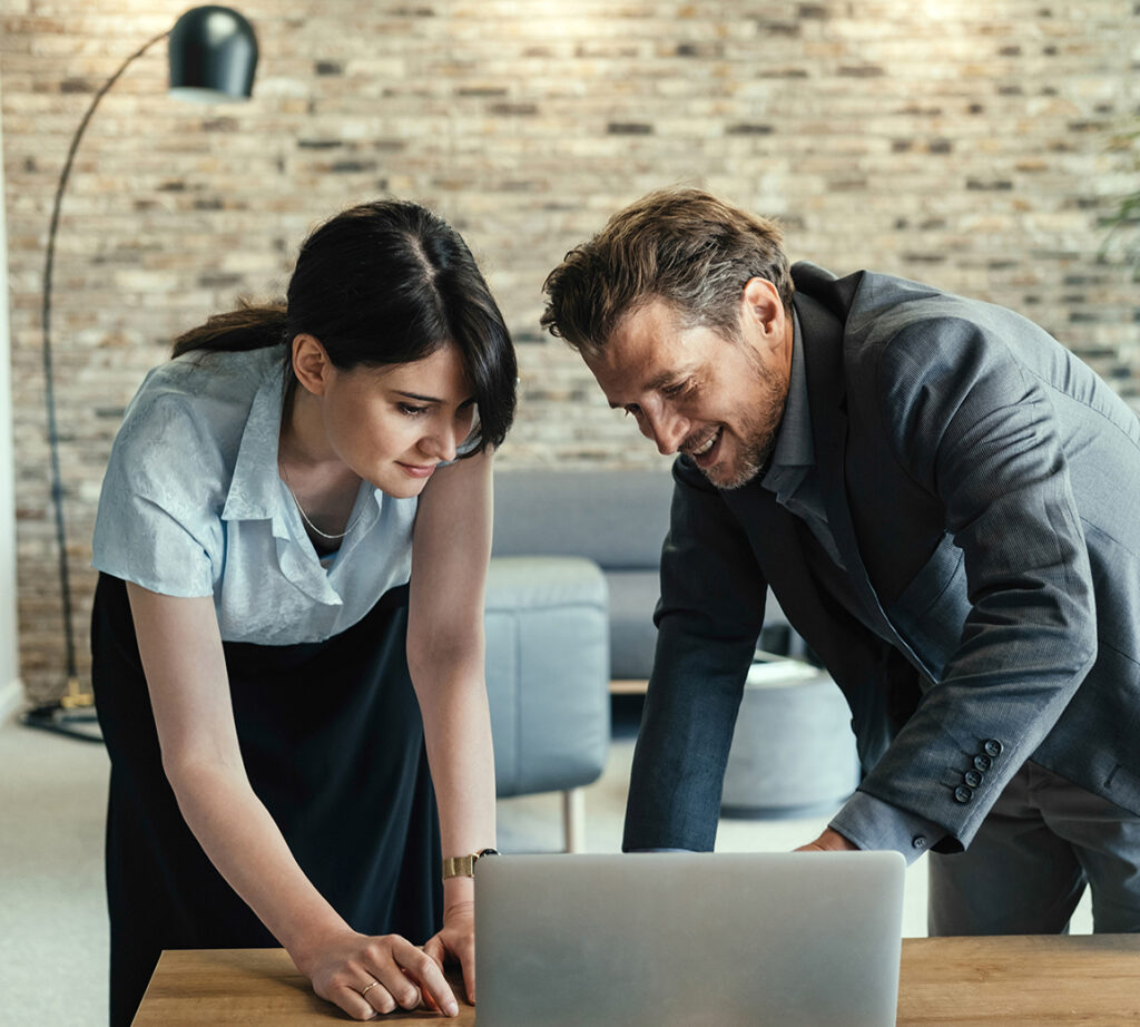 Two colleagues are discussing things on a laptop