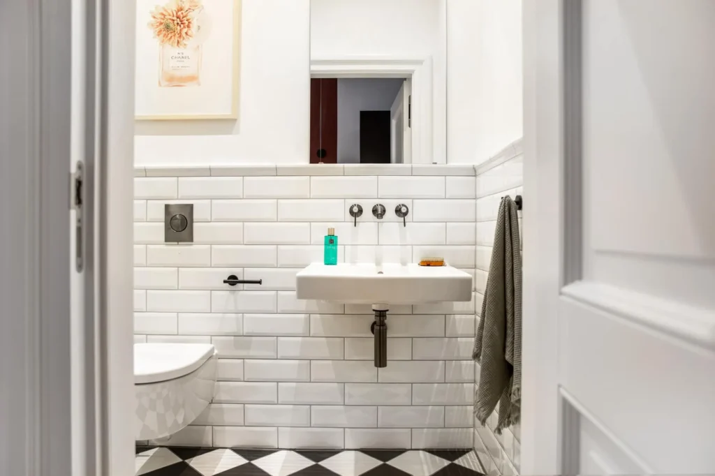 Bathroom with subway tiles, sink and checkerboard floor in the Medium apartment, ipartment Berlin Kurfürstendamm