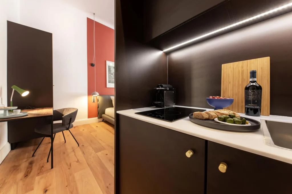 Dark kitchenette with coffee machine and work area next to the bed in the Smart apartment, ipartment Berlin Kurfürstendamm