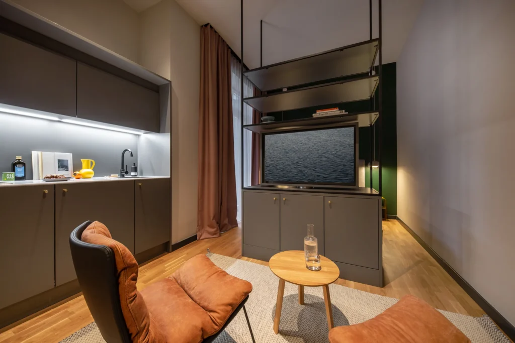 Kitchenette with TV unit, armchair and side table in Apartment S, ipartment Berlin Mitte
