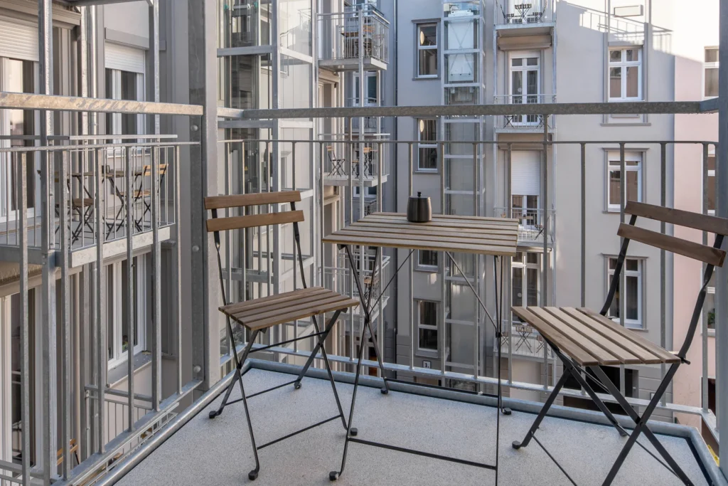 Balcony with folding table and two chairs overlooking the courtyard in Apartment S+, ipartment Berlin Mitte