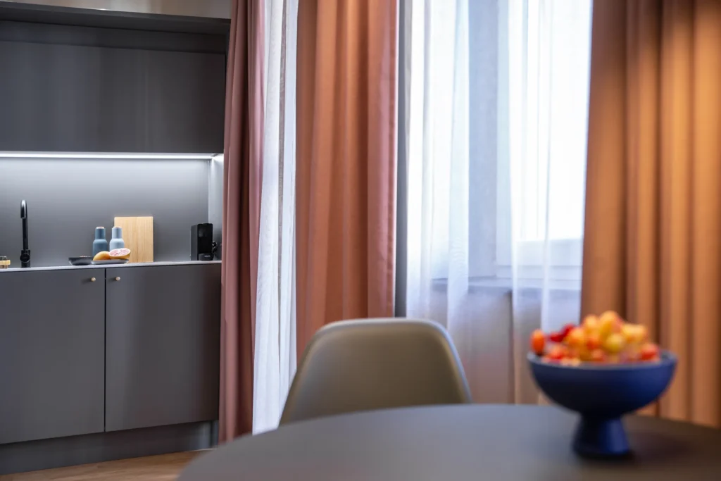 Kitchenette with round table and fruit bowl in front of the window in Apartment S+, ipartment Berlin Mitte