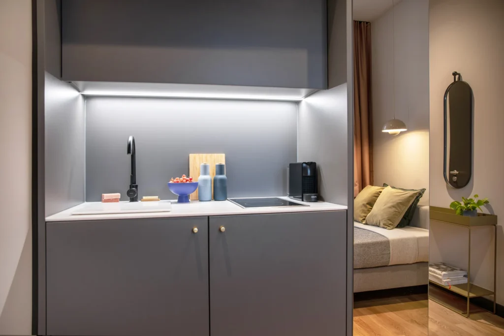 Kitchenette with cooking stove, sink and coffee machine in the XS apartment, ipartment Berlin Mitte