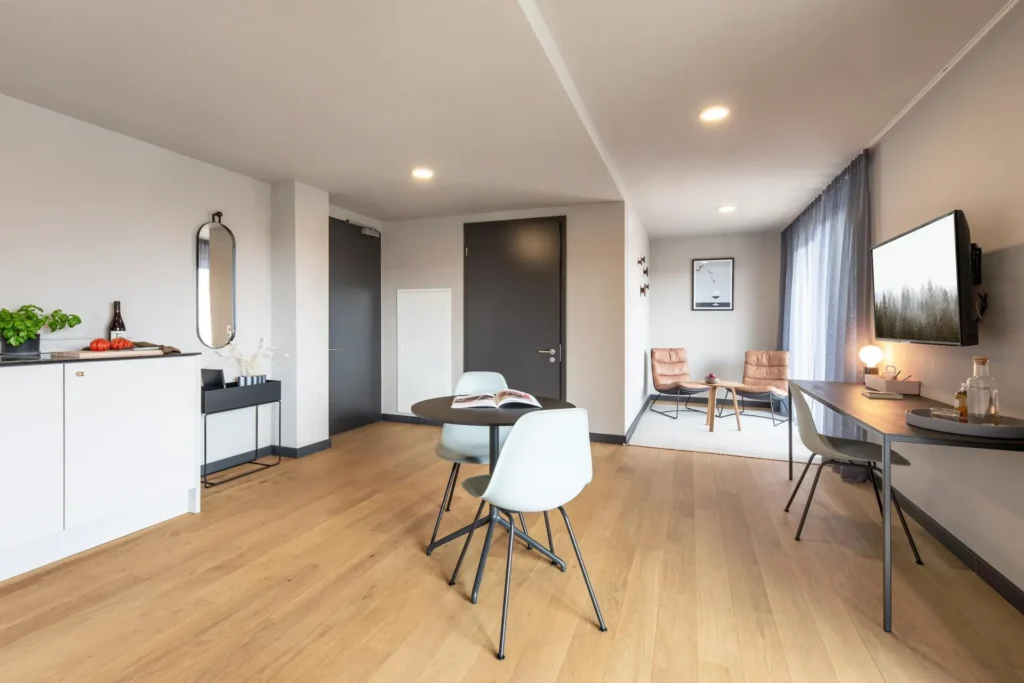 Living space with dining table, kitchenette, entrance area and seating area by the window in the Luxury apartment, ipartment Böblingen-Sindelfingen