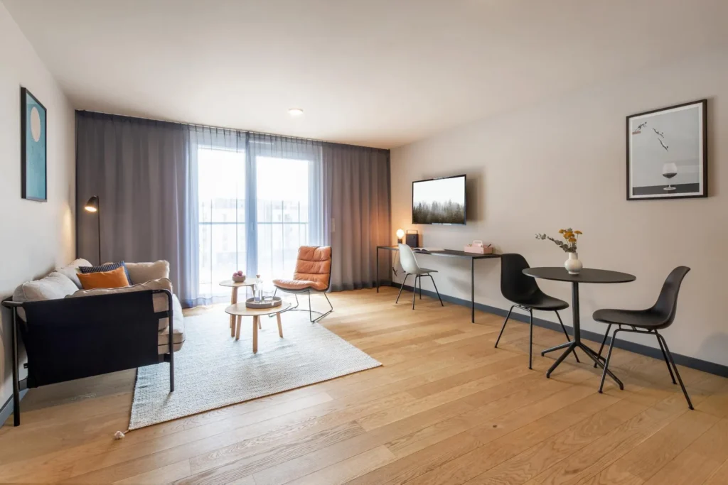 Living area with sofa, dining table with chairs and work area in the Medium apartment, ipartment Böblingen-Sindelfingen