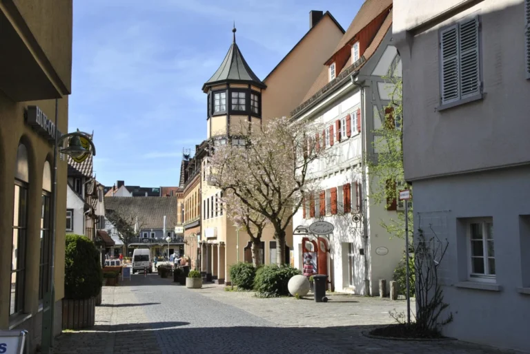 Cobblestone street with historic houses, turrets and flowering trees in Böblingen