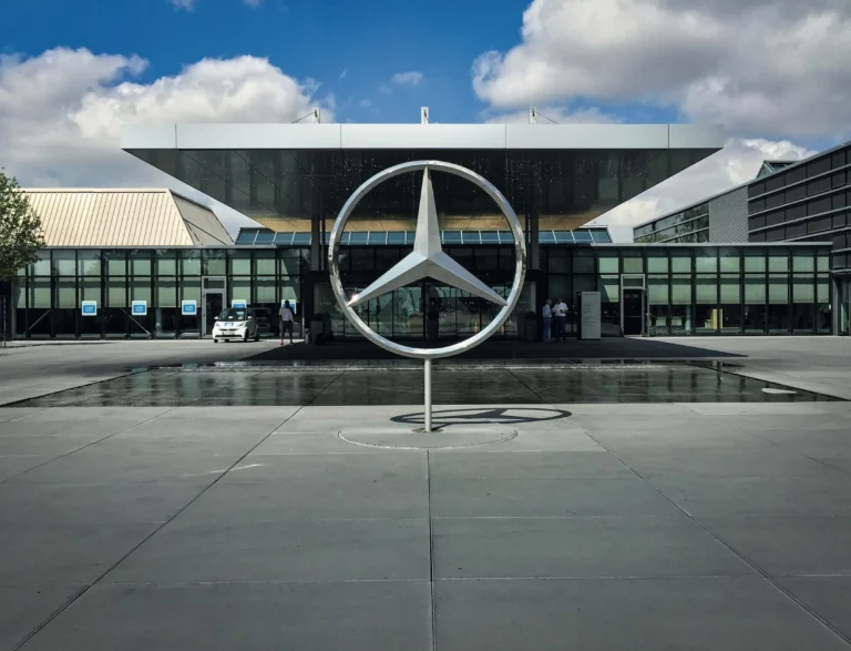 Mercedes star in front of a building with a glass facade and a water basin, Mercedes-Benz in Böblingen