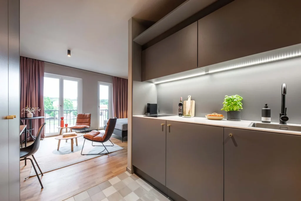 Kitchenette and living area with armchairs and balcony door in apartment S, apartment Braunschweig
