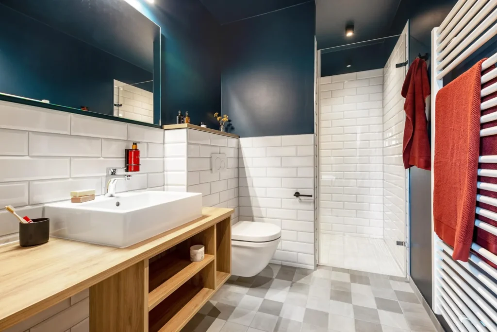 Bathroom with white subway tiles, wooden washbasin, shower and towel heater in apartment S, apartment Braunschweig