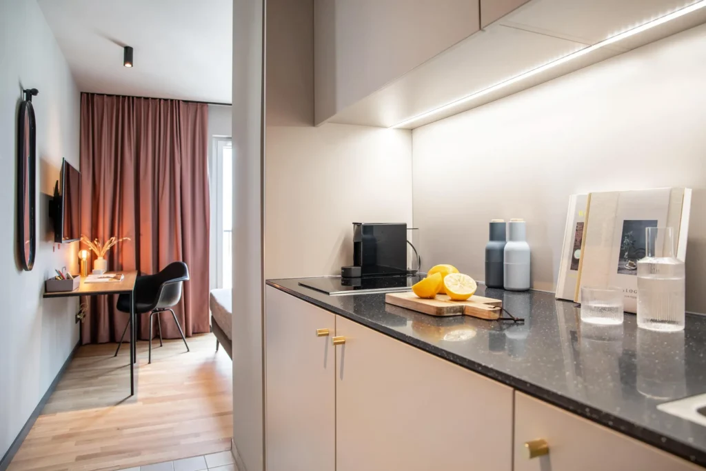 Kitchenette with coffee machine and lemon press; in the background, workspace in apartment XS, ipartment Braunschweig