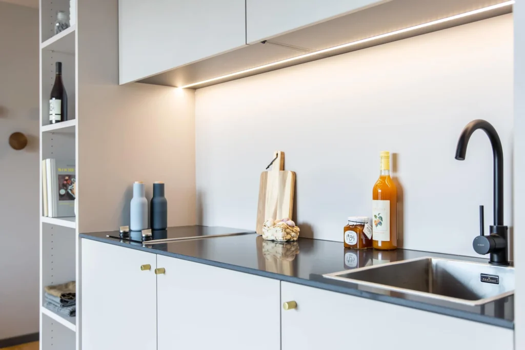 Kitchenette with cooking stove, black faucet and shelf in the Luxury apartment, ipartment Darmstadt