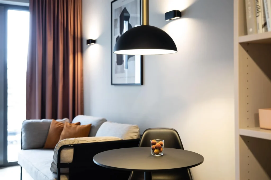 Black pendant light over round table in front of sofa in Medium apartment, ipartment Darmstadt
