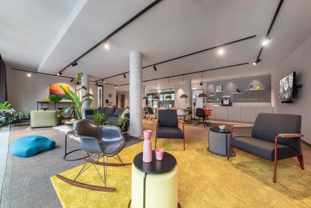Extensive Vitra lounge with armchairs, carpets and kitchenette on the ground floor, ipartment Darmstadt