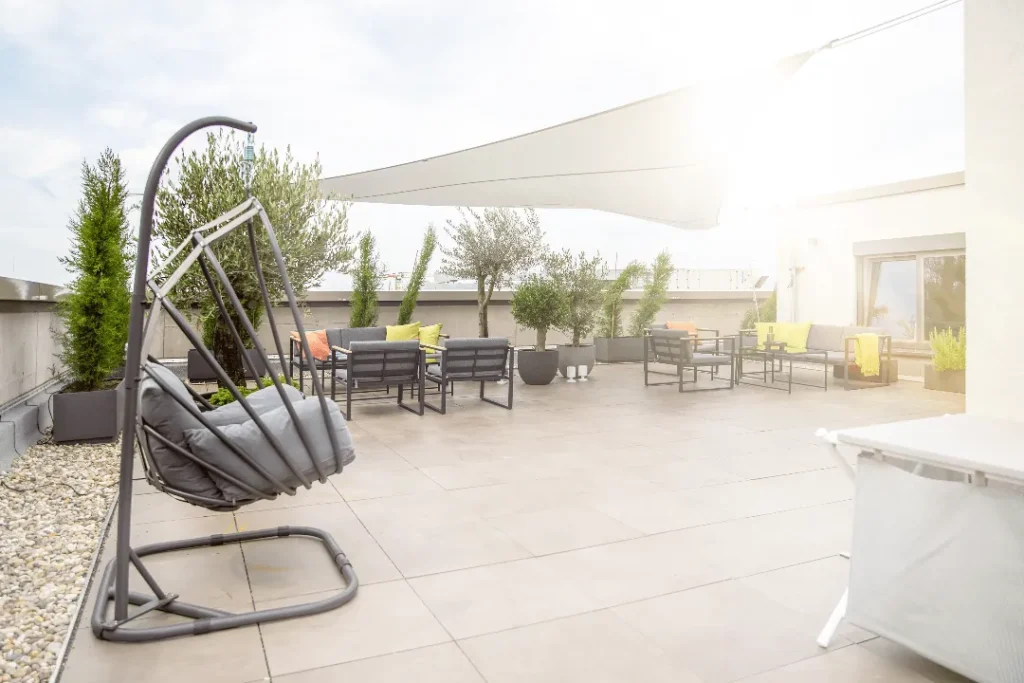 Roof terrace with hanging chairs, lounge furniture and sun canopy, ipartment Darmstadt