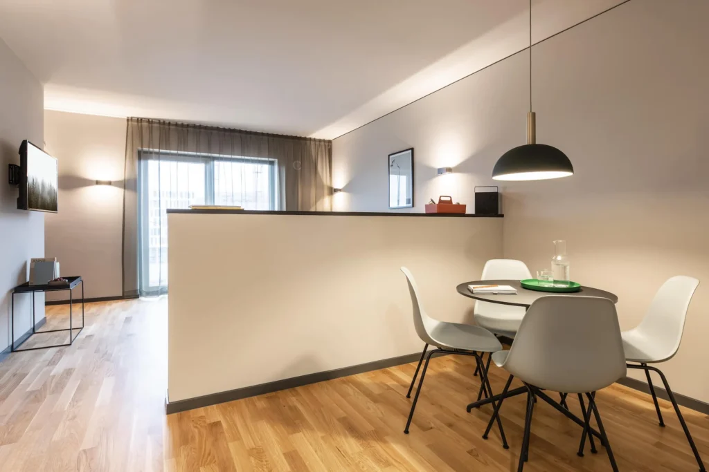 Dining area with round table, chairs and pendant light in Apartment M, ipartment Frankfurt Airport