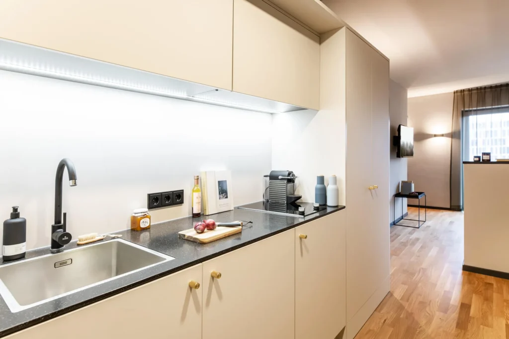 Kitchenette with sink and coffee machine in Apartment M, ipartment Frankfurt Airport