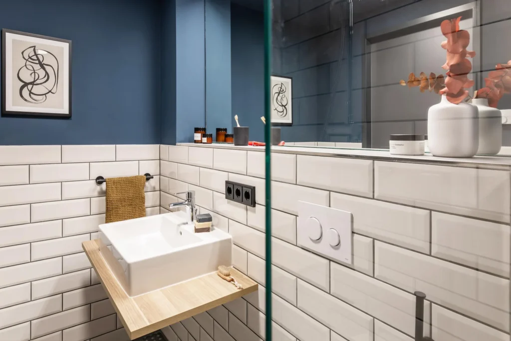 Bathroom with sink, subway tiles and glass shower in apartment S, ipartment Frankfurt Airport