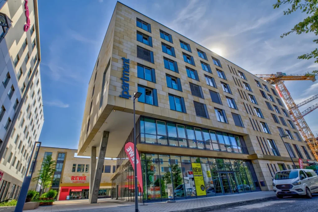 Buildings in Gateway Gardens with ipartment logo and REWE market on the ground floor, Frankfurt