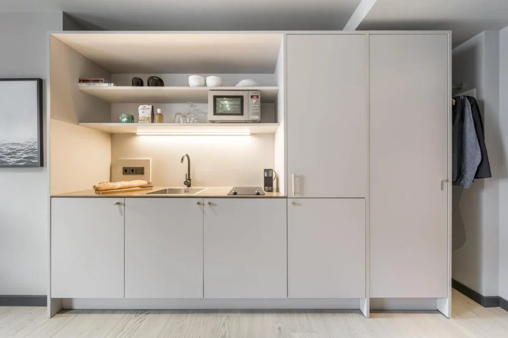 Kitchenette with shelves, microwave and sink in the Medium apartment, ipartment Frankfurt Bahnhofsviertel