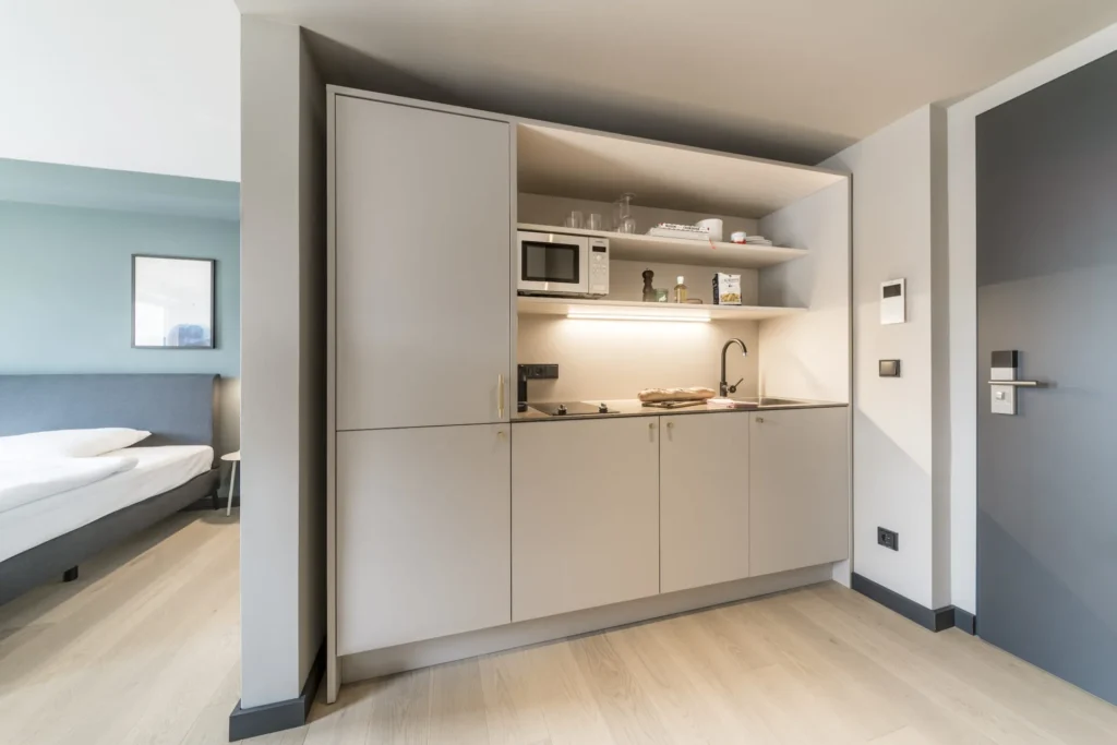Kitchen cabinet with microwave next to the bed in the Smart apartment, ipartment Frankfurt Bahnhofsviertel