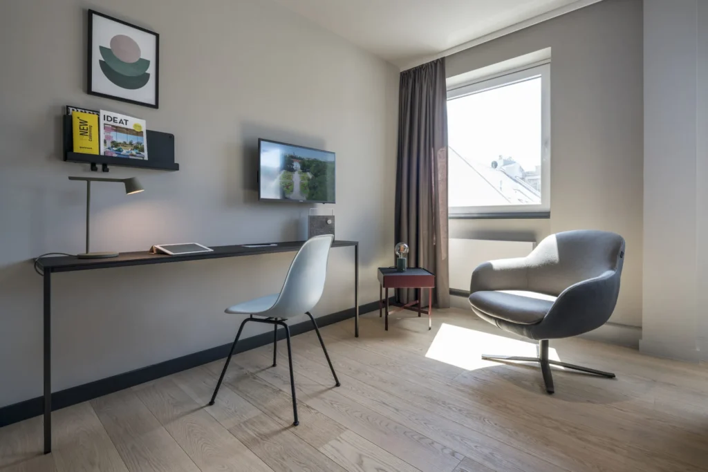 Desk with TV and armchair by the window in the Smart apartment, ipartment Frankfurt Bahnhofsviertel