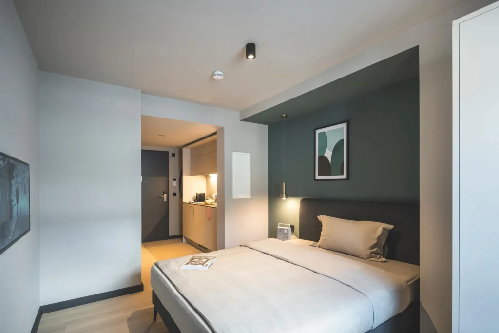 Schlafbereich mit Doppelbett und Blick in den Eingangsflur im Apartment Xtra Smart, ipartment Frankfurt Bahnhofsviertel