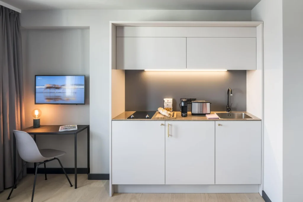 Kitchenette with work area and TV in the Xtra Smart apartment, ipartment Frankfurt Bahnhofsviertel
