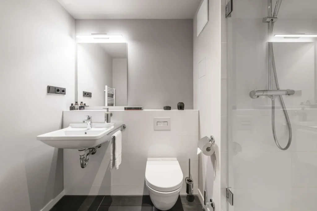 Bathroom with sink, toilet and shower in the Xtra Smart apartment, ipartment Frankfurt Bahnhofsviertel