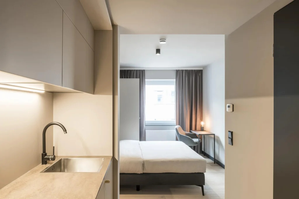 Looking past the kitchen area at the bed in the Xtra Smart apartment, ipartment Frankfurt Bahnhofsviertel