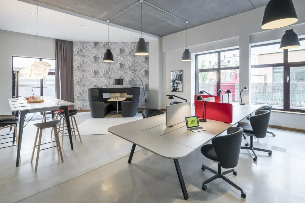 Coworking space with a large work desk, hanging lights and a seating area in the European Quarter in Frankfurt, Frankfurt am Main