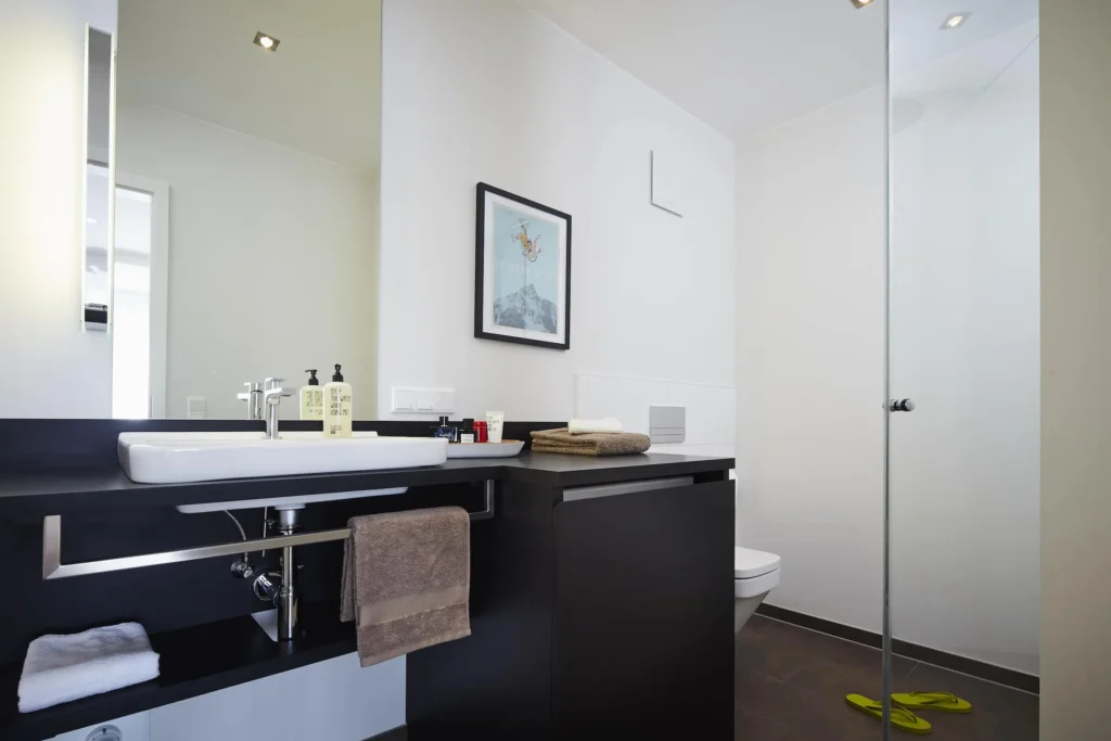 Bathroom with sink, mirror and glass shower in Apartment M, ipartment Frankfurt Europaviertel