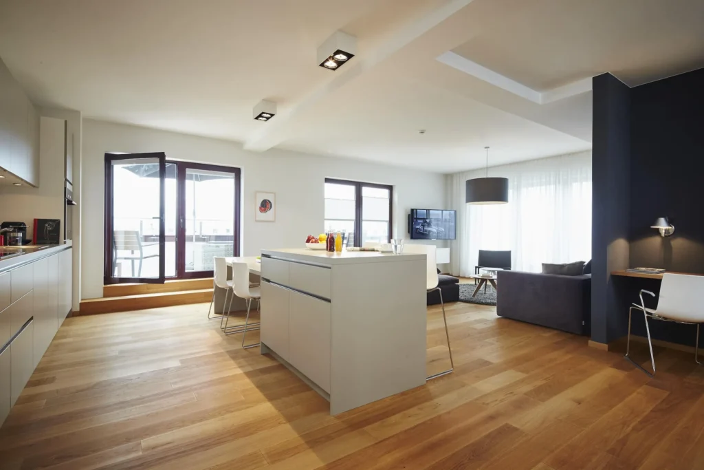 Spacious living space with an island kitchen, dining area and access to the roof terrace in the XL apartment, ipartment Frankfurt Europaviertel