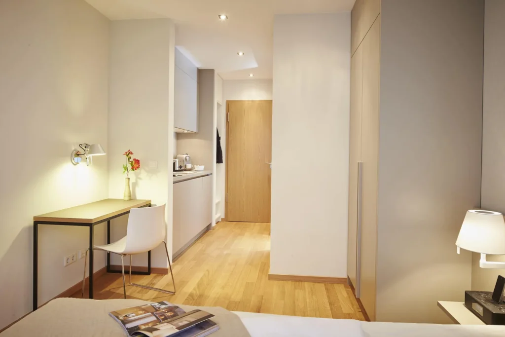 Entrance area with kitchenette, work area and bed in the XS apartment, ipartment Frankfurt Europaviertel