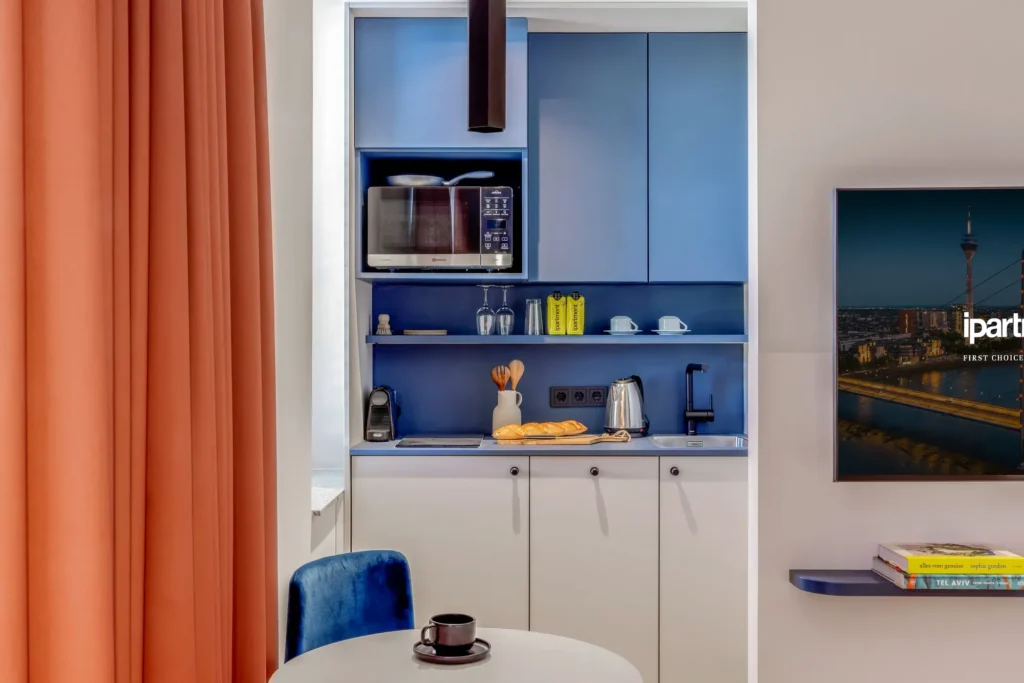 Example image: Kitchenette in blue with microwave, kettle and bread, placeholder for ipartment Fürth
