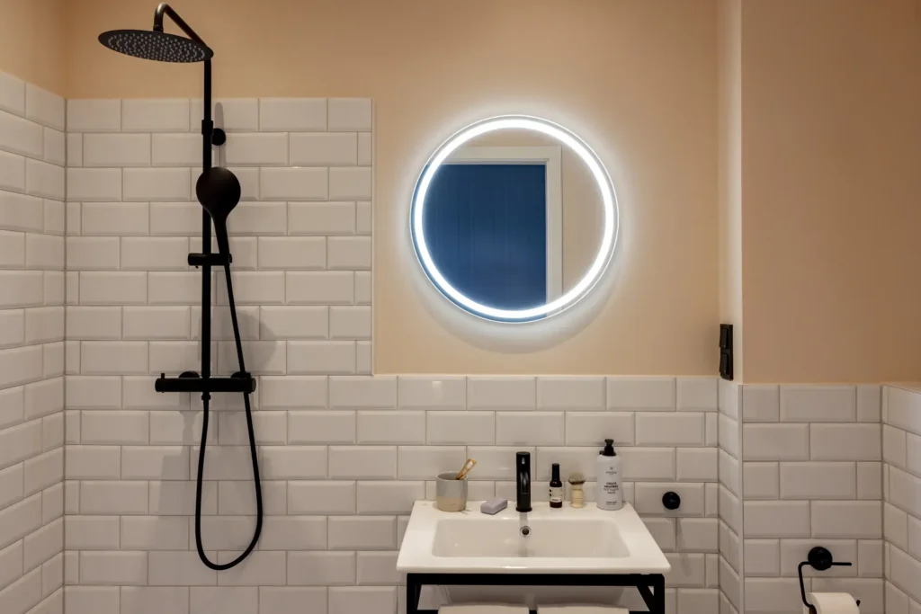 Example image: Bathroom with tiled shower, black faucet and illuminated round mirror, placeholder for ipartment Fürth