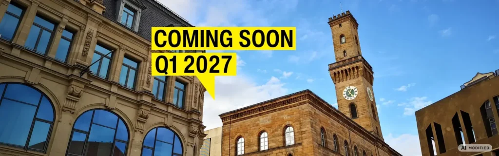 Stone facade with round arch windows and town hall tower in Fürth under a blue sky with the sign „Coming soon Q1 2027“