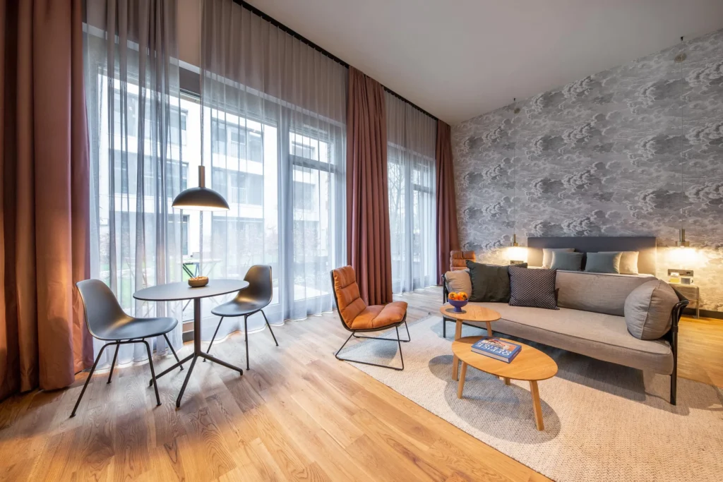 Bright loft atmosphere with floor-to-ceiling windows, dining table and armchair in the Luxury apartment, ipartment Hamburg Eimsbüttel
