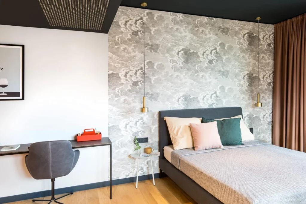 Double bed and desk with chair in front of the wall mural in Apartment M, ipartment Hamburg HafenCity