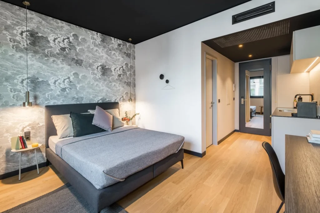 Double bed with a view through the hallway to the kitchen in Apartment S, Hamburg HafenCity