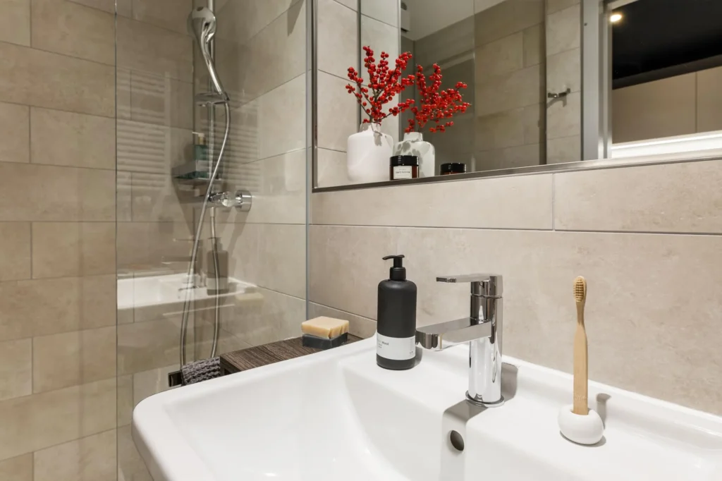 Washbasin with faucet and shower in the bathroom of Apartment S, apartment Hamburg HafenCity