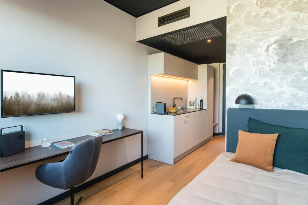 View from the bed towards the desk, TV and kitchenette in the XS apartment, ipartment Hamburg HafenCity
