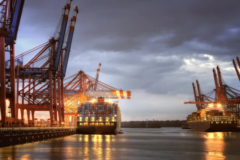Container ship and harbor cranes in the Hamburg harbor at dusk