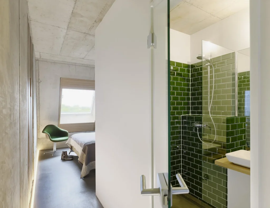 View through the hallway to the bedroom and into the green tiled shower room in Apartment M, apartment Cologne Mülheim