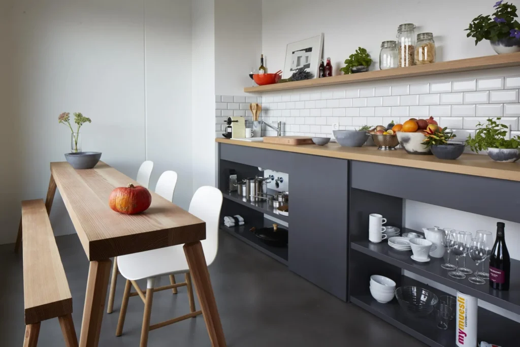 Kitchenette with wooden worktop, shelves, dining table and bench in the XL apartment, ipartment Cologne Mülheim