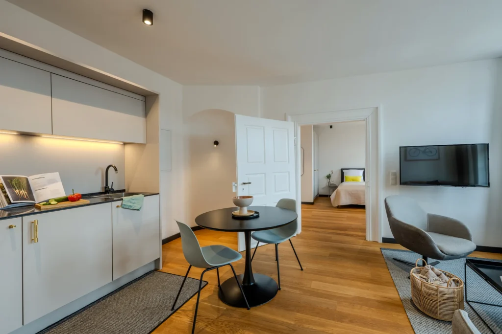 Kitchenette with dining table, open sliding door to the bedroom, ipartment Wolfsburg
