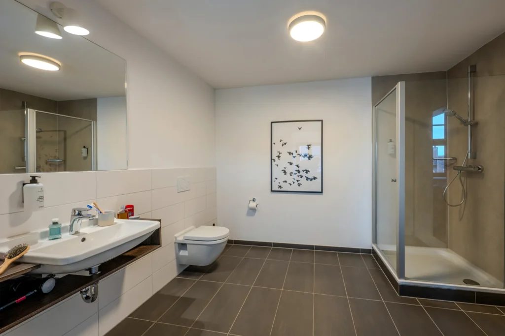 Large bathroom with sink, toilet and corner shower, ipartment Wolfsburg