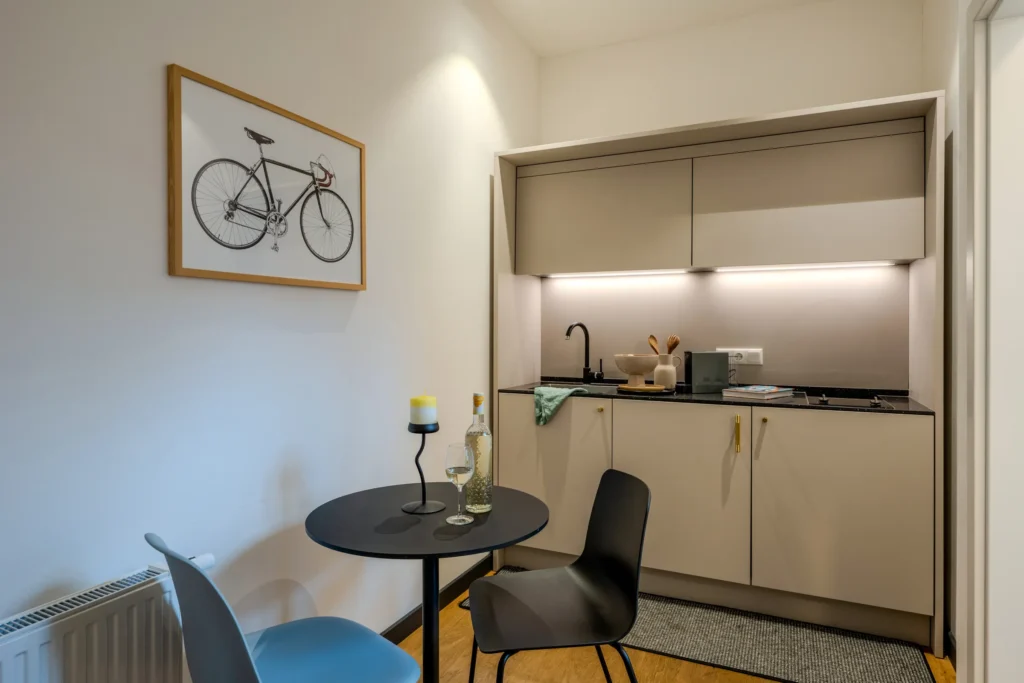Kitchen area with round dining table and a picture of a racing bike on the wall, ipartment Wolfsburg