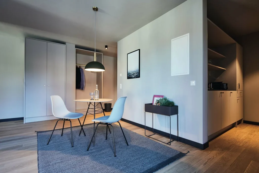 Dining area with two chairs, wardrobe and kitchenette in the XL apartment, ipartment Wolfsburg